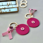 Porte-clés ronds Atelier Guillocher en cuir rose fuchsia avec ruban Octobre Rose pour la Ligue contre le cancer